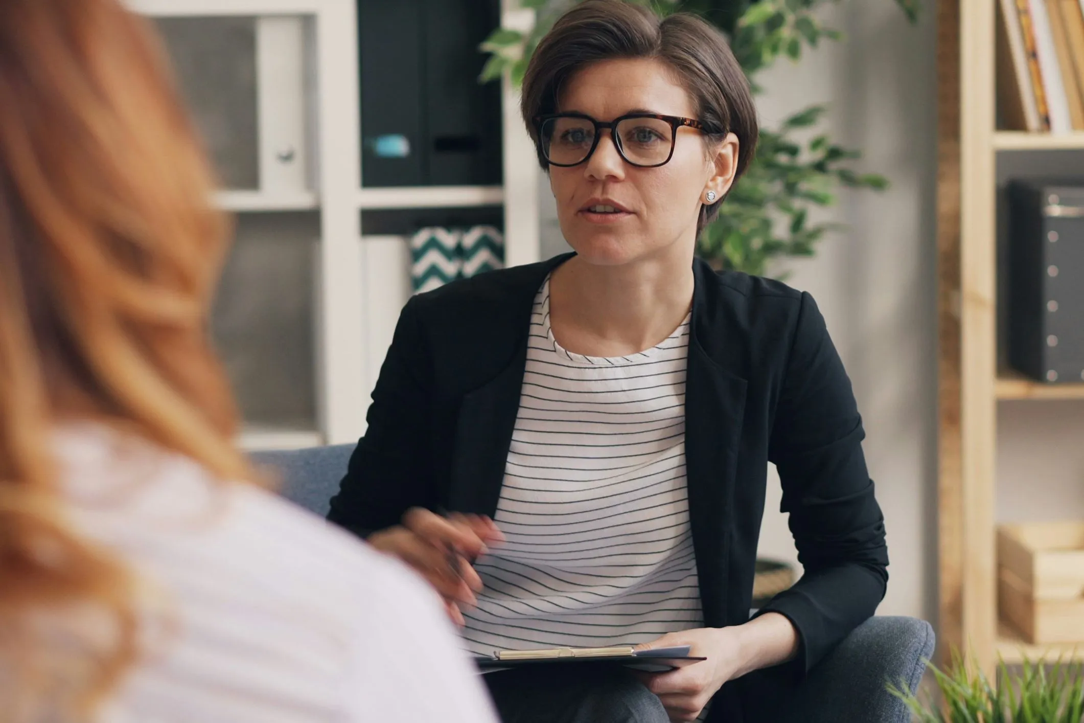 Woman wearing glasses in a discussion.